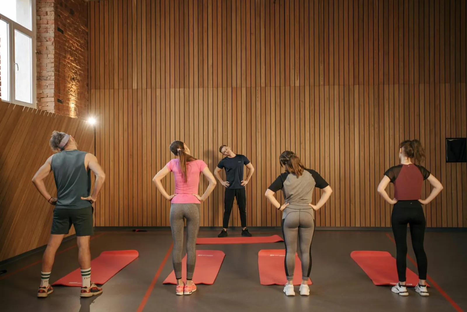 Personal trainer leading group fitness class with movement coaching